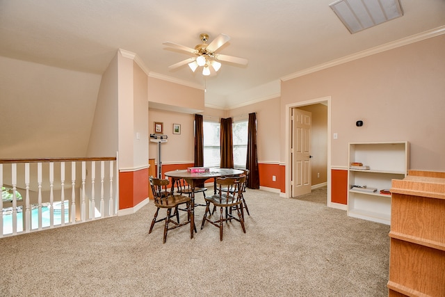 dining space with carpet flooring, ceiling fan, and crown molding