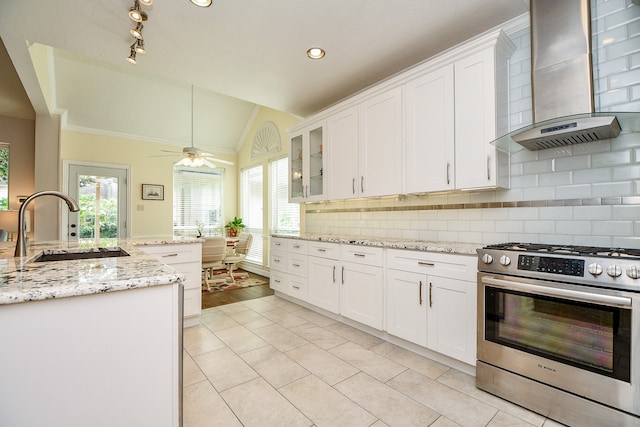 kitchen with white cabinetry, wall chimney exhaust hood, high end stainless steel range oven, and lofted ceiling