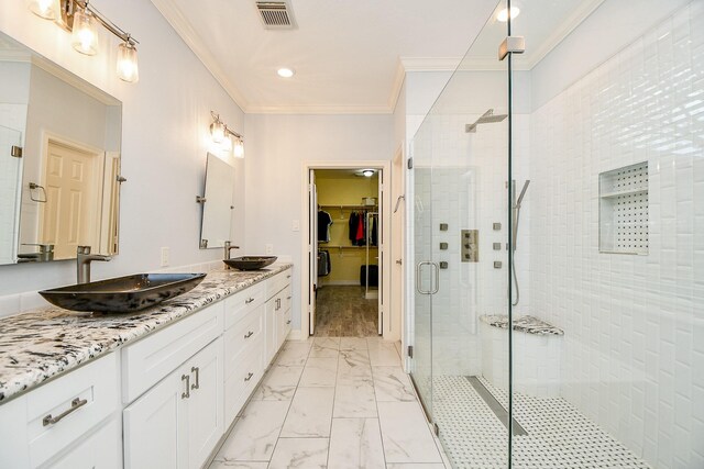 bathroom featuring a shower with door, vanity, and ornamental molding