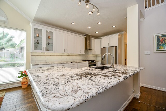 kitchen featuring white cabinetry, a large island with sink, wall chimney range hood, and dark hardwood / wood-style flooring