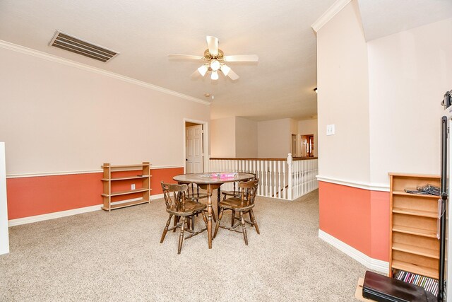 dining space featuring ceiling fan, carpet floors, and ornamental molding