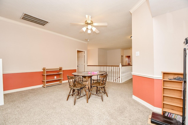 carpeted dining area with ceiling fan, ornamental molding, visible vents, and baseboards