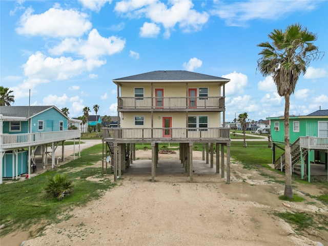 exterior space featuring a front lawn, a balcony, and a carport