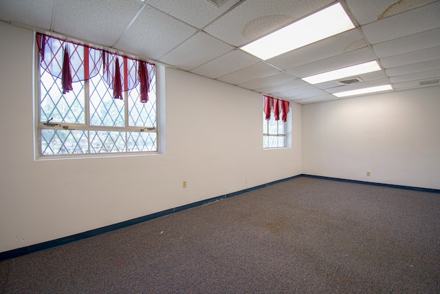 empty room featuring a drop ceiling and carpet