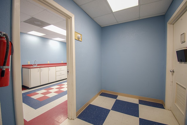 interior space featuring a paneled ceiling and sink