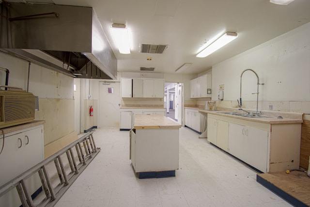 kitchen featuring white cabinetry, sink, and a center island