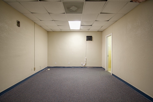 unfurnished room featuring carpet and a paneled ceiling