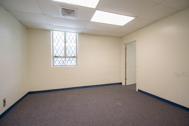 carpeted spare room featuring a paneled ceiling