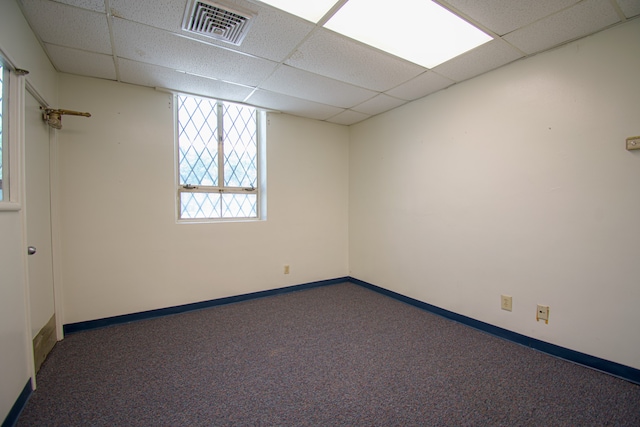 carpeted spare room with a drop ceiling