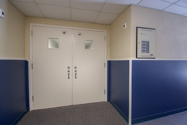 interior space with carpet flooring and a drop ceiling