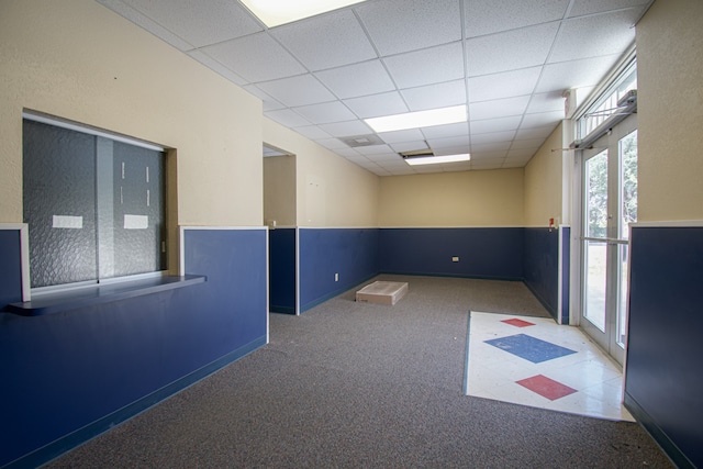 spare room featuring a drop ceiling and carpet