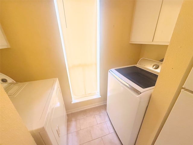 clothes washing area with washer and clothes dryer and light tile patterned floors