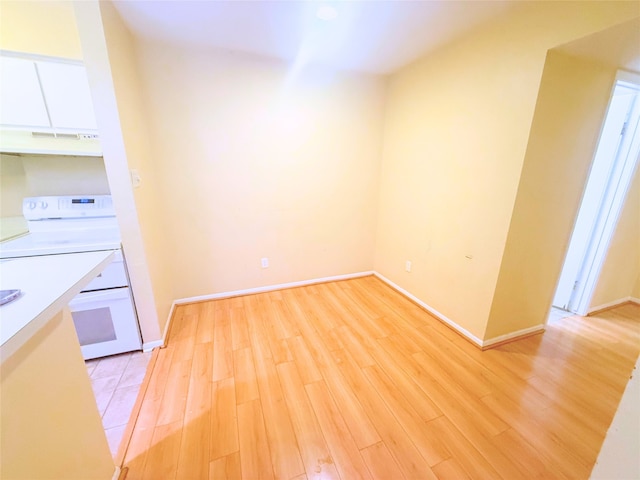 kitchen with white cabinetry, light hardwood / wood-style floors, exhaust hood, and white electric range oven