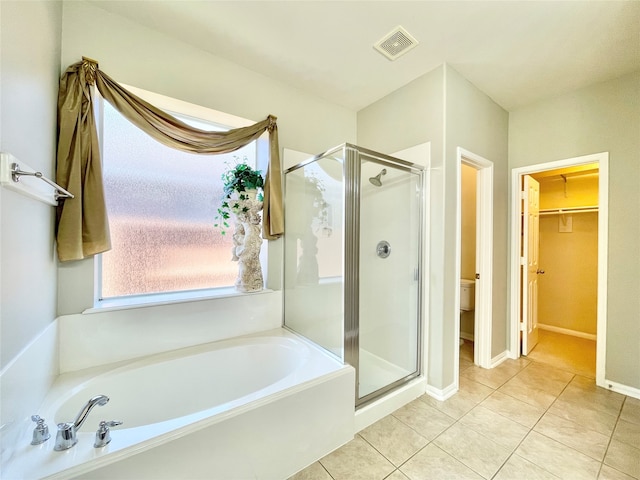 bathroom with tile patterned flooring and shower with separate bathtub