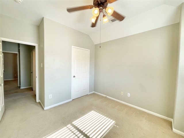 unfurnished bedroom featuring ceiling fan, light carpet, and vaulted ceiling