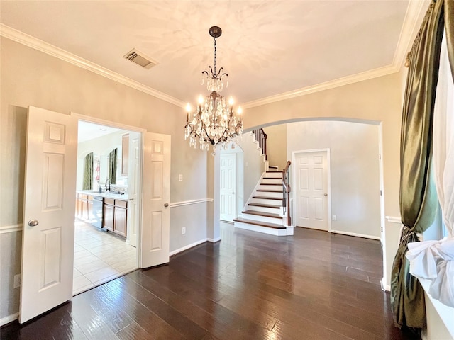 unfurnished dining area with wood-type flooring, ornamental molding, and an inviting chandelier