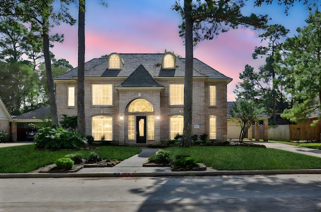 view of front of home with a front lawn, fence, and brick siding