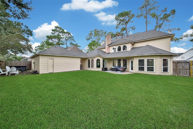 rear view of house with a fenced backyard, a shingled roof, a lawn, a chimney, and a patio area