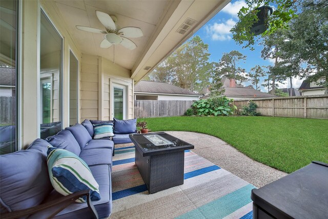 view of patio featuring ceiling fan and an outdoor living space with a fire pit