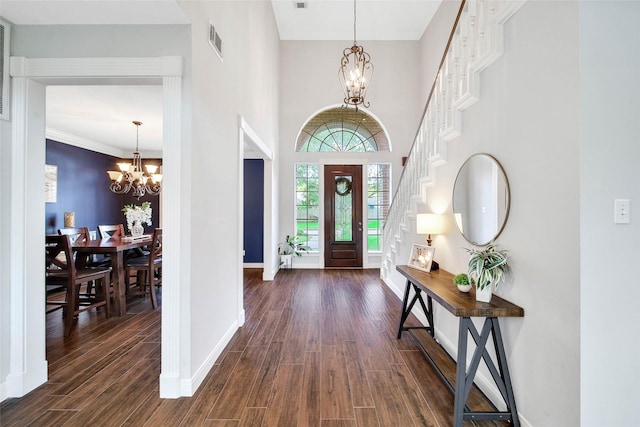 foyer with visible vents, a chandelier, and dark wood-type flooring