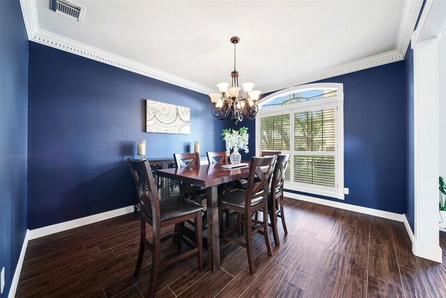 dining space featuring a chandelier, dark hardwood / wood-style floors, and crown molding