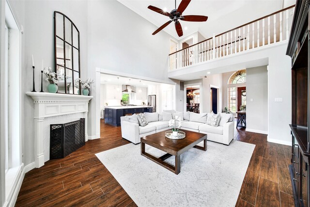 living room with a high ceiling, a wealth of natural light, and ceiling fan