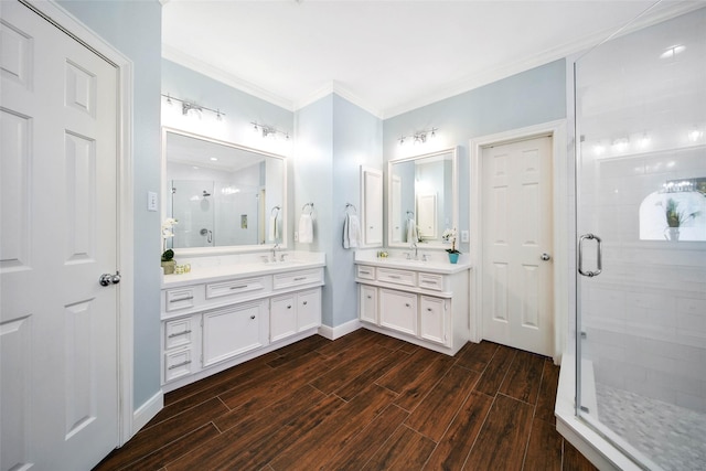 bathroom featuring two vanities, ornamental molding, a stall shower, wood tiled floor, and baseboards