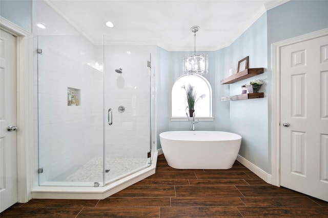 full bath featuring a stall shower, baseboards, ornamental molding, wood tiled floor, and a freestanding bath