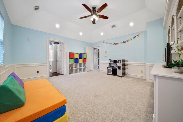 game room with light carpet, a tray ceiling, ceiling fan, and lofted ceiling