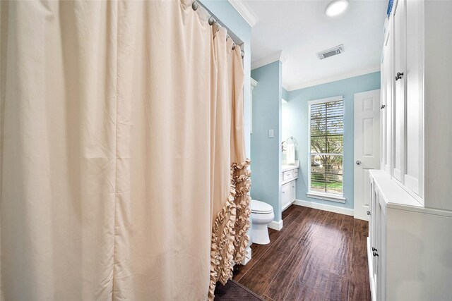 bathroom featuring wood-type flooring, vanity, toilet, and ornamental molding