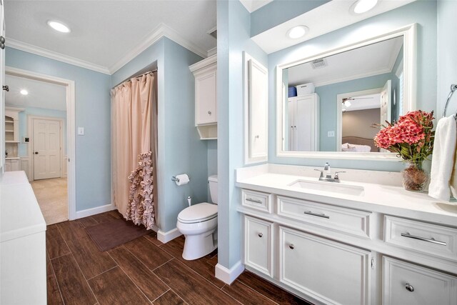 bathroom featuring vanity, toilet, and crown molding