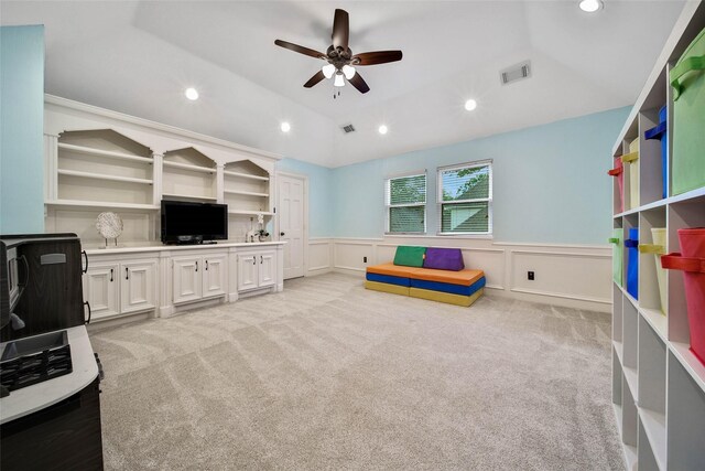 interior space featuring ceiling fan, light colored carpet, and lofted ceiling