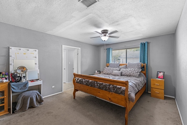 bedroom with ceiling fan, a textured ceiling, and light carpet