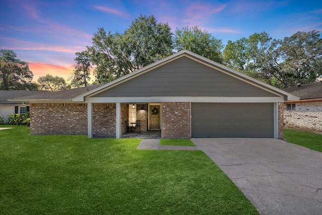 ranch-style home featuring a lawn, brick siding, and concrete driveway