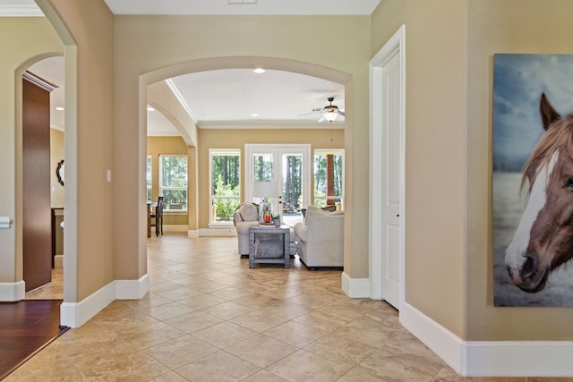 corridor with ornamental molding and light hardwood / wood-style flooring