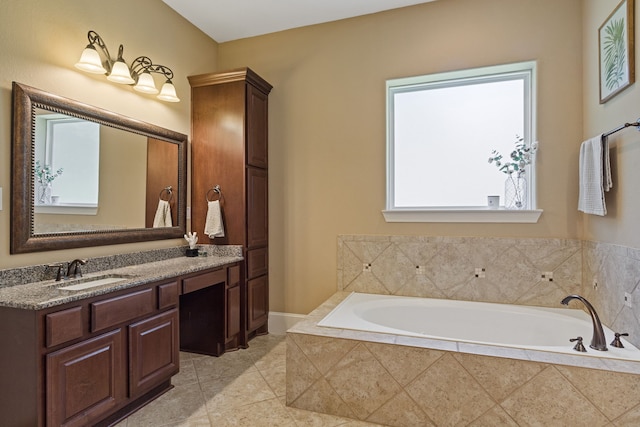 bathroom with a relaxing tiled tub, vanity, and tile patterned floors