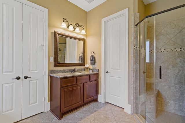 bathroom featuring vanity, tile patterned floors, and a shower with door