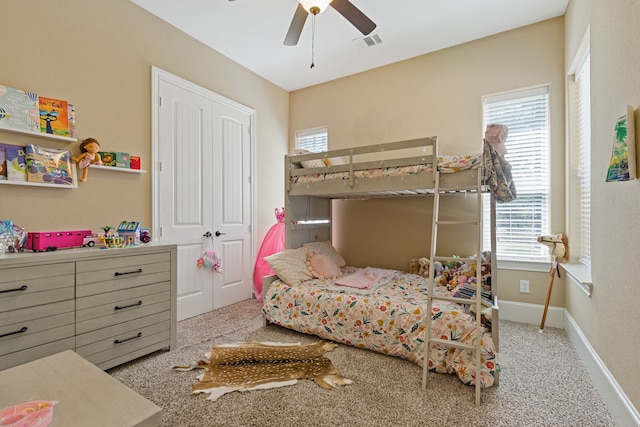 bedroom with a closet, light colored carpet, and ceiling fan