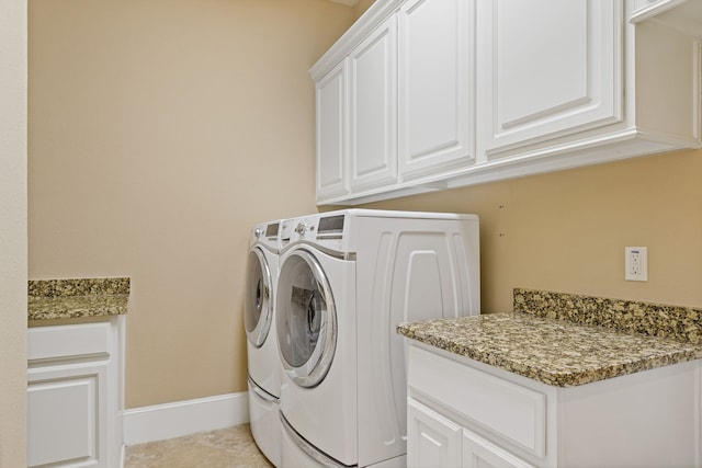 laundry area featuring cabinets, washer and dryer, and light tile patterned floors