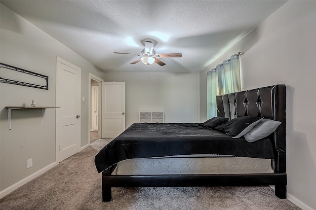 bedroom featuring ceiling fan, light colored carpet, and a textured ceiling