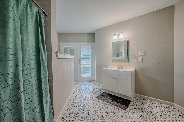 bathroom featuring a shower with shower curtain, vanity, and french doors