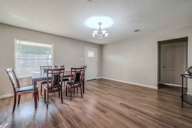 dining room featuring a textured ceiling, dark hardwood / wood-style floors, and a notable chandelier