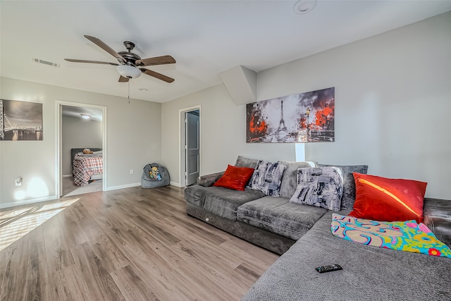 living room featuring ceiling fan and hardwood / wood-style floors