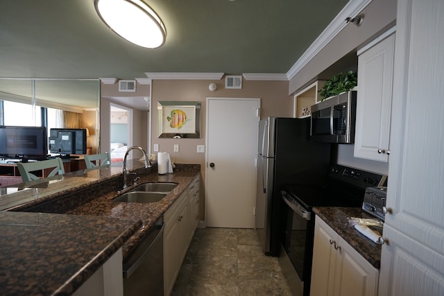 kitchen featuring white cabinetry, sink, appliances with stainless steel finishes, dark stone counters, and crown molding