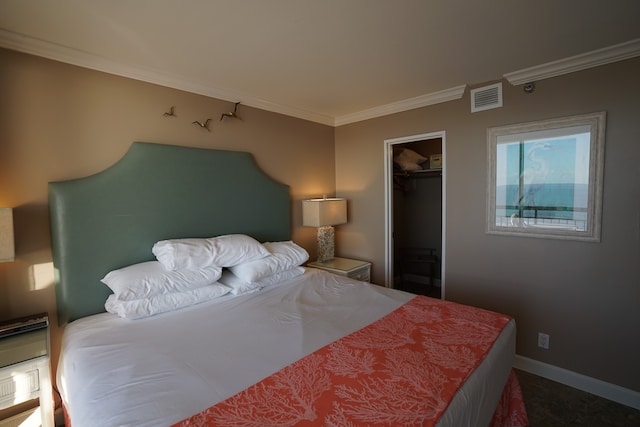 bedroom with a closet, a walk in closet, and ornamental molding