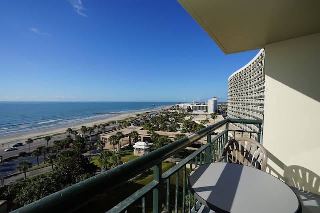 balcony featuring a view of the beach and a water view