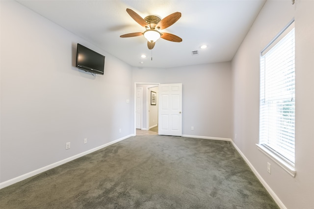 empty room with dark carpet and ceiling fan