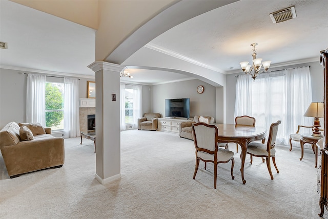 dining room featuring a fireplace, plenty of natural light, light carpet, and crown molding