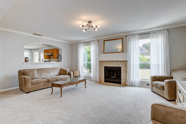 carpeted living room featuring ornamental molding, a fireplace, and a chandelier