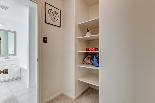 hall featuring sink and light tile patterned floors